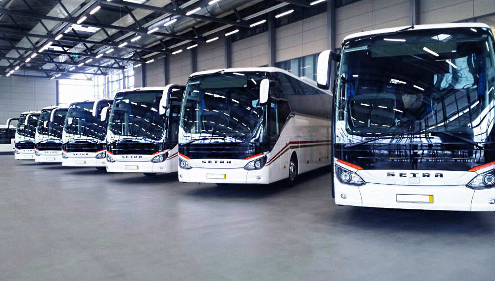 Flota de autobuses de la Federación Empresarial Catalana de Autotransporte de Viajeros Autobuses de FECAV estacionados en hangar de transporte en Cataluña